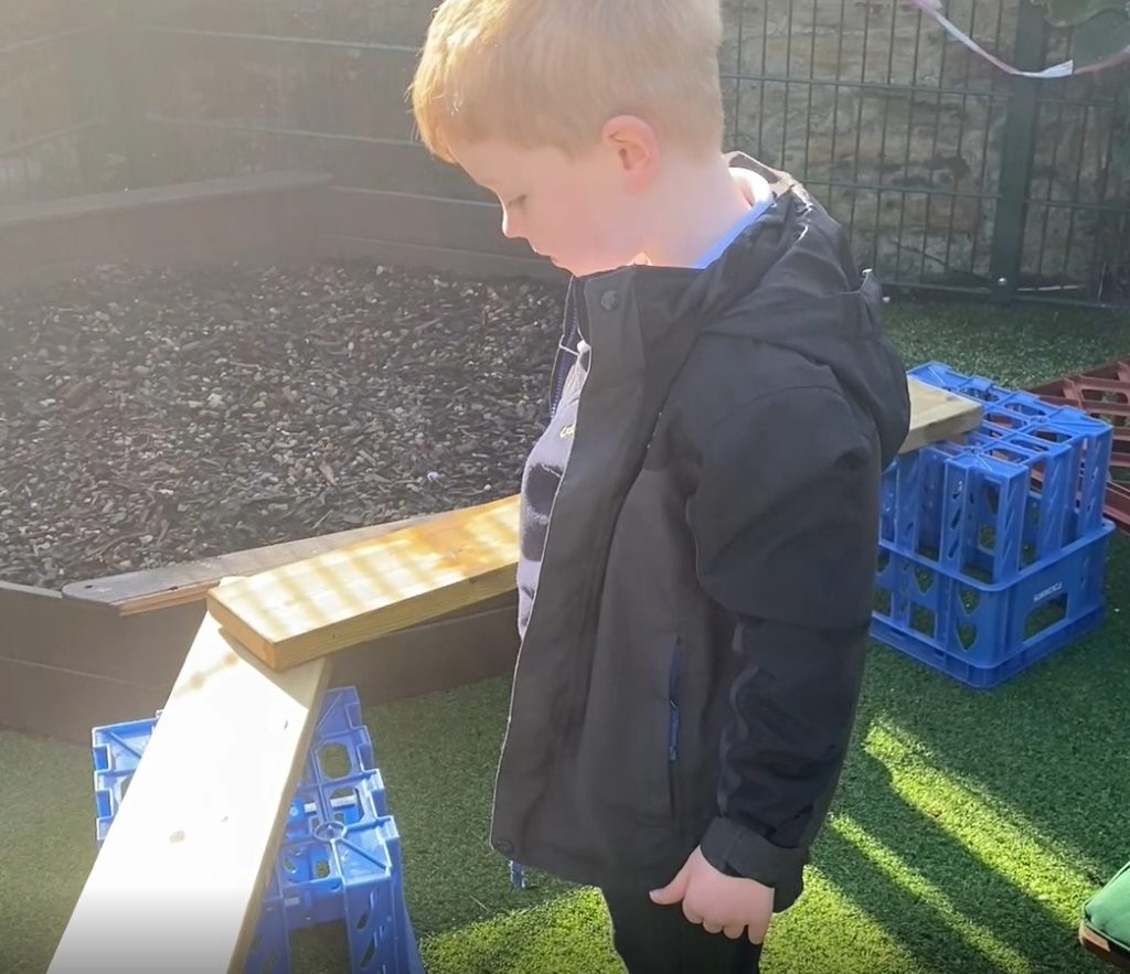 Little boy works out how to fix the problem with the balance beams.