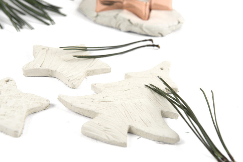 using pine needles to create patterns in clay shapes