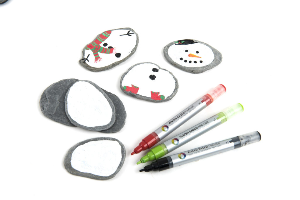 Stones, paint and paint markers for making mix and match snow people.