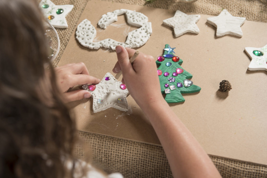 Girl makes patters on clay star