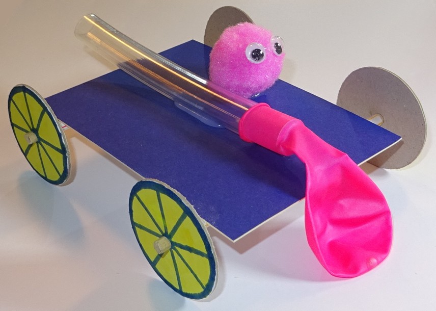 Image shows a balloon buggy with deflated balloon and pompom passenger on top. 