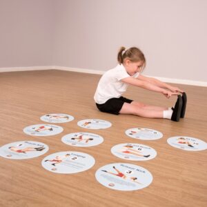 TTS Fitness Sequence Floor Spot Markers spread out on the floor with a school child copying one of the moves shown on the markers.