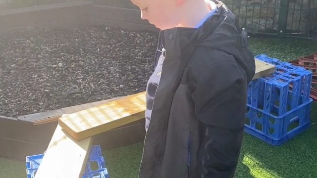 Little boy works out how to fix the problem with the balance beams.