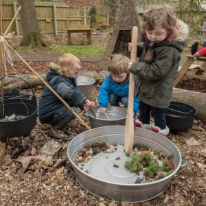 Children enjoying Outdoor Learning with giant spoons and pans.