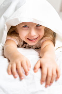 Child hiding under a blanket