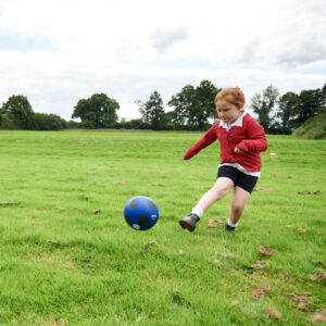 Girl kicking football