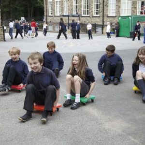 Children playing on sit on scooters