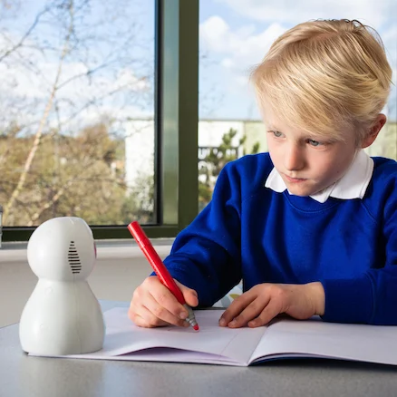 School child using Kitt robot to help him write a text.