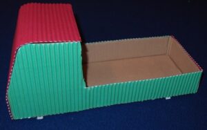 Cardboard shaped cabin covered in red and green coloured corrugated card.