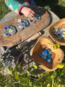 A small child adding gems to some air-dry clay hearts