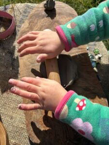 A small child rolling out some air-dry clay